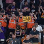 Fans watch players warm up before Game 2 of basketball's NBA Finals between the Phoenix Suns and the Milwaukee Bucks, Thursday, July 8, 2021, in Phoenix. (AP Photo/Ross D. Franklin)