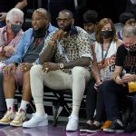 Los Angeles Lakers basketball player LeBron James, center, watches during the first half of Game 5 of basketball's NBA Finals between the Phoenix Suns and the Milwaukee Bucks, Saturday, July 17, 2021, in Phoenix. (AP Photo/Ross D. Franklin)