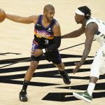 Phoenix Suns guard Chris Paul (3) is defended by Milwaukee Bucks guard Jrue Holiday during the first half of Game 5 of basketball's NBA Finals, Saturday, July 17, 2021, in Phoenix. (AP Photo/Matt York)