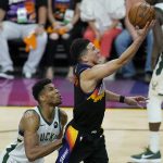 Phoenix Suns guard Devin Booker, right, shoots over Milwaukee Bucks forward Giannis Antetokounmpo during the second half of Game 5 of basketball's NBA Finals, Saturday, July 17, 2021, in Phoenix. (AP Photo/Ross D. Franklin)