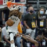 
              Milwaukee Bucks forward Giannis Antetokounmpo, top, dunks over Phoenix Suns guard Chris Paul during the second half of Game 5 of basketball's NBA Finals, Saturday, July 17, 2021, in Phoenix. (AP Photo/Ross D. Franklin)
            
