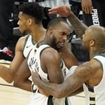 
              Milwaukee Bucks' Giannis Antetokounmpo, from left, celebrates with Khris Middleton and P.J. Tucker during the second half of Game 5 of basketball's NBA Finals against the Phoenix Suns, Saturday, July 17, 2021, in Phoenix. (AP Photo/Matt York)
            