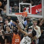 Milwaukee Bucks forward Giannis Antetokounmpo (34) blocks a shot by Phoenix Suns center Deandre Ayton (22) during the second half of Game 4 of basketball's NBA Finals Wednesday, July 14, 2021, in Milwaukee. (AP Photo/Aaron Gash)