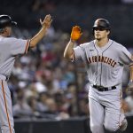 San Francisco Giants' Alex Dickerson, right, celebrates his home run against the Arizona Diamondbacks with third base coach Ron Wotus (23) during the third inning of a baseball game Friday, July 2, 2021, in Phoenix. (AP Photo/Ross D. Franklin)
