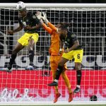
              Jamaica forward Cory Burke (9) and defender Liam Moore (6) help goalkeeper Andre Blake (1) against a shot by the United States in the first half of a CONCACAF Gold Cup quarterfinals soccer match, Sunday, July 25, 2021, in Arlington, Texas. (AP Photo/Brandon Wade)
            
