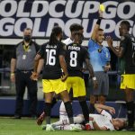 
              Jamaica midfielder Daniel Johnson (16) and Oniel Fisher (8) look on as Damion Lowe (17) receives a yellow card from referee Cesar Ramos after knocking down United States defender Sam Vines, on ground, in the second half of a CONCACAF Gold Cup quarterfinals soccer match, Sunday, July 25, 2021, in Arlington, Texas. (AP Photo/Brandon Wade)
            