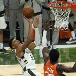 Milwaukee Bucks forward Giannis Antetokounmpo (34) shoots over Phoenix Suns center Deandre Ayton, right, during the second half of Game 4 of basketball's NBA Finals in Milwaukee, Wednesday, July 14, 2021. (AP Photo/Paul Sancya)