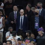 NBA Commissioner Adam Silver, center, watches during the first half of Game 5 of basketball's NBA Finals between the Phoenix Suns and the Milwaukee Bucks, Saturday, July 17, 2021, in Phoenix. (AP Photo/Ross D. Franklin)