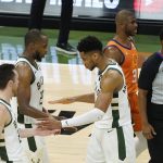 Milwaukee Bucks forward Giannis Antetokounmpo celebrates with teammates guard Pat Connaughton, left, and forward Khris Middleton, center, at the end of Game 4 against the Phoenix Suns in basketball's NBA Finals in Milwaukee, Wednesday, July 14, 2021. (AP Photo/Paul Sancya)