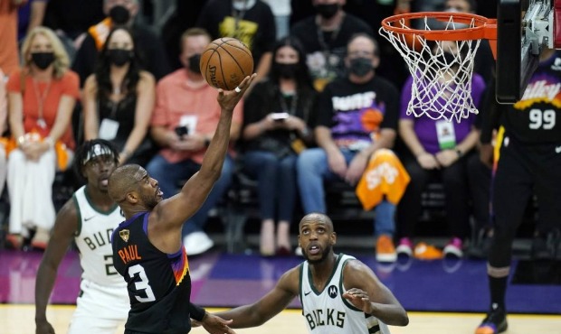 Phoenix Suns guard Chris Paul (3) scores as Milwaukee Bucks forward Khris Middleton (22) and Bucks ...