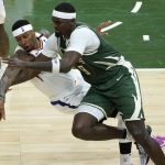 Phoenix Suns forward Torrey Craig (12) and Milwaukee Bucks center Bobby Portis (9) battle for the ball during the second half of Game 3 of basketball's NBA Finals in Milwaukee, Sunday, July 11, 2021. (AP Photo/Paul Sancya)