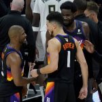 Phoenix Suns guard Devin Booker (1) greets guard Chris Paul, left, after Game 1 of basketball's NBA Finals against the Milwaukee Bucks, Tuesday, July 6, 2021, in Phoenix. The Suns won 118-105. (AP Photo/Matt York)