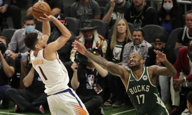 Phoenix Suns' Devin Booker (1) shoots against Milwaukee Bucks' P.J. Tucker (17) during the second h...