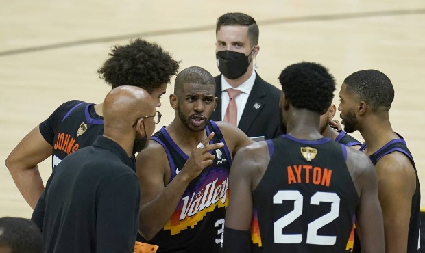 Phoenix Suns guard Chris Paul, middle, huddles with head coach Monty Williams, bottom left, center ...