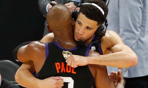 JULY 06: Devin Booker #1 and Chris Paul #3 of the Phoenix Suns hug after the team's win against the...
