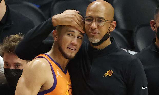Head coach Monty Williams of the Phoenix Suns hugs Devin Booker #1 in the final seconds of the team...