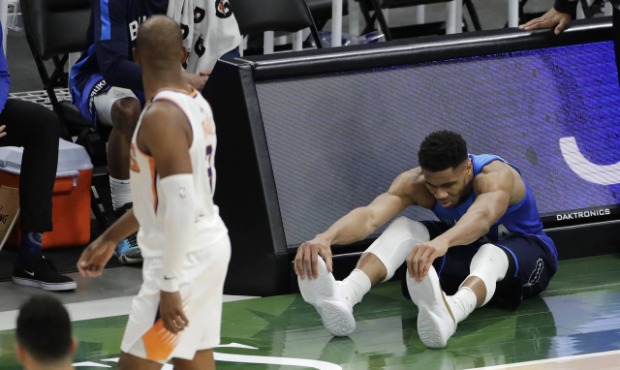 Milwaukee Bucks Giannis Antetokounmpo goes to the ground after injuring his leg during overtime of ...