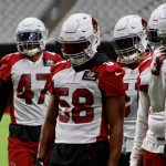 Cardinals LB Jordan Hicks (58) and others wait to run through drills during training camp Friday, July 30, 2021, in Glendale. (Tyler Drake/Arizona Sports)