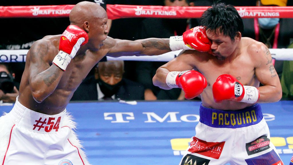 Yordenis Ugas (L) hits Manny Pacquiao in the sixth round of their WBA welterweight title fight at T...