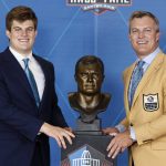 John Lynch, a member of the Pro Football Hall of Fame Class of 2021, right, poses with the trophy with his son, Jake, during the induction ceremony at the Pro Football Hall of Fame, Sunday, Aug. 8, 2021, in Canton, Ohio. (AP Photo/Ron Schwane, Pool)