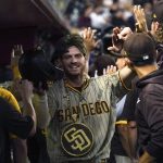 San Diego Padres' Wil Myers is greeted in the dugout after hitting a two-run home run off Arizona Diamondbacks' Madison Bumgarner during the seventh inning of a baseball game Friday, Aug 13, 2021, in Phoenix. (AP Photo/Darryl Webb)