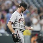Arizona Diamondbacks starting pitcher Tyler Gilbert looks at a new ball after giving up a two-run home run to Colorado Rockies' Garrett Hampson during the second inning of a baseball game Friday, Aug. 20, 2021, in Denver. (AP Photo/David Zalubowski)