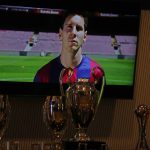 A video screen shows images of Lionel Messi next to some of the trophies he won while playing for Barcelona before a press conference at the Camp Nou stadium in Barcelona, Spain, Sunday, Aug. 8, 2021. FC Barcelona had previously announced the negotiations with Lionel Messi had ended and that Messi would be leaving the club. (AP Photo/Joan Monfort)