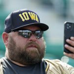 A baseball fan makes a photo with his phone before a baseball game between the Chicago White Sox and New York Yankees, Thursday, Aug. 12, 2021 in Dyersville, Iowa. The Yankees and White Sox are playing at a temporary stadium in the middle of a cornfield at the Field of Dreams movie site, the first Major League Baseball game held in Iowa. (AP Photo/Charlie Neibergall)