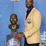 Calvin Johnson, a member of the Pro Football Hall of Fame Class of 2021, poses with his bust during the induction ceremony at the Pro Football Hall of Fame, Sunday, Aug. 8, 2021, in Canton, Ohio. (AP Photo/Ron Schwane, Pool)