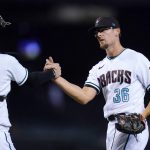 Arizona Diamondbacks relief pitcher Tyler Clippard (36) celebrates with catcher Carson Kelly after the final out of the team's baseball game against the San Francisco Giants, Tuesday, Aug. 3, 2021, in Phoenix. The Diamondbacks won 3-1. (AP Photo/Ross D. Franklin)