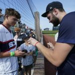 Chicago White Sox pitcher Lucas Giolito signs autographs before a baseball game against the New York Yankees, Thursday, Aug. 12, 2021 in Dyersville, Iowa. The Yankees and White Sox are playing at a temporary stadium in the middle of a cornfield at the Field of Dreams movie site, the first Major League Baseball game held in Iowa. (AP Photo/Charlie Neibergall)