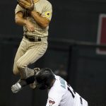 Arizona Diamondbacks' Nick Ahmed, bottom, blocks San Diego Padres second baseman Adam Fraizer, top, from kicking him in the face at the start a double play during the first inning of a baseball game Friday, Aug 13, 2021, in Phoenix. (AP Photo/Darryl Webb)