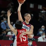 United States' Diana Taurasi (12) passes over Japan's Nako Motohashi (15) during women's basketball gold medal game at the 2020 Summer Olympics, Sunday, Aug. 8, 2021, in Saitama, Japan. (AP Photo/Charlie Neibergall)