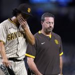 San Diego Padres starting pitcher Yu Darvish, left, leaves the game with Padres head athletic trainer Mark Rogow during the third inning of the team's baseball game against the Arizona Diamondbacks, Thursday, Aug. 12, 2021, in Phoenix. (AP Photo/Ross D. Franklin)