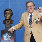 Tom Flores, a member of the Pro Football Hall of Fame Class of 2021, poses with his bust during the induction ceremony at the Pro Football Hall of Fame, Sunday, Aug. 8, 2021, in Canton, Ohio. (AP Photo/Ron Schwane, Pool)