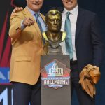 John Lynch, a member of the Pro Football Hall of Fame Class of 2021, left, and his son, Jake, smile after unveiling the bust during the induction ceremony at the Pro Football Hall of Fame, Sunday, Aug. 8, 2021, in Canton, Ohio. (AP Photo/David Richard)