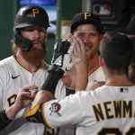 Pittsburgh Pirates' Colin Moran, left, is greeted in the dugout by Kevin Newman, right, and Steven Brault, center, after scoring on a double by Jacob Stallings in the fourth inning of a baseball game against the Arizona Diamondbacks, Monday, Aug. 23, 2021, in Pittsburgh. (AP Photo/Keith Srakocic)
