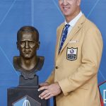 Peyton Manning, a member of the Pro Football Hall of Fame Class of 2021, poses with a bust of himself during the induction ceremony at the Pro Football Hall of Fame, Sunday, Aug. 8, 2021, in Canton, Ohio. (AP Photo/Ron Schwane, Pool)