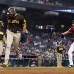 San Diego Padres' Fernando Tatis Jr., second from left, scores a run on a wild pitch from Arizona Diamondbacks pitcher Sean Poppen (64) as Padres' Tommy Pham, left, pauses at home plate during the eighth inning of a baseball game, Sunday, Aug. 15, 2021, in Phoenix. (AP Photo/Ross D. Franklin)