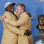 John Lynch, a member of the Pro Football Hall of Fame Class of 2021, right, hugs Warren Sapp during the induction ceremony at the Pro Football Hall of Fame, Sunday, Aug. 8, 2021, in Canton, Ohio. (AP Photo/Ron Schwane, Pool)