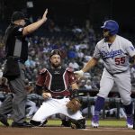 Los Angeles Dodgers' Albert Pujols (55) reacts with MLB umpire Greg Gibson, left, after hitting Arizona Diamondbacks catcher Bryan Holaday, center, with his back swing in the first inning during a baseball game, Sunday, Aug 1, 2021, in Phoenix. (AP Photo/Rick Scuteri)