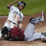 Pittsburgh Pirates' Ke'Bryan Hayes, left, scores as Arizona Diamondbacks catcher Carson Kelly tries to tag him, on a sacrifice fly by Jacob Stallings during the fourth inning of a baseball game Wednesday, Aug. 25, 2021, in Pittsburgh. (AP Photo/Keith Srakocic)