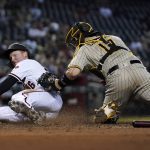 San Diego Padres catcher Victor Caratini, right, tags out Arizona Diamondbacks' Pavin Smith at home plate during the fourth inning of a baseball game Thursday, Aug. 12, 2021, in Phoenix. (AP Photo/Ross D. Franklin)