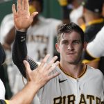 Pittsburgh Pirates' Kevin Newman is greeted by teammates in the dugout after scoring on a ground out by Ke'Bryan Hayes, top, in the eighth inning of a baseball game against the Arizona Diamondbacks, Monday, Aug. 23, 2021, in Pittsburgh. The Pirates won 6-5. (AP Photo/Keith Srakocic)