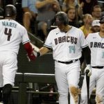 Arizona Diamondbacks' Ketel Marte is congratulated by Asdrubal Cabrera, center, and Carson Kelly, right, after his solo home run against the San Diego Padres during the fifth inning of a baseball game Friday, Aug 13, 2021, in Phoenix. (AP Photo/Darryl Webb)