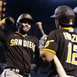 San Diego Padres' Eric Hosmer, left, smiles as he celebrates his home run against the Arizona Diamondbacks with Padres' Adam Frazier (12) during the seventh inning of a baseball game Monday, Aug. 30, 2021, in Phoenix. (AP Photo/Ross D. Franklin)