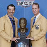 Peyton Manning, right, a member of the Pro Football Hall of Fame Class of 2021, poses with a bust of himself with Steve Hutchinson during the induction ceremony at the Pro Football Hall of Fame, Sunday, Aug. 8, 2021, in Canton, Ohio. (AP Photo/Ron Schwane, Pool)