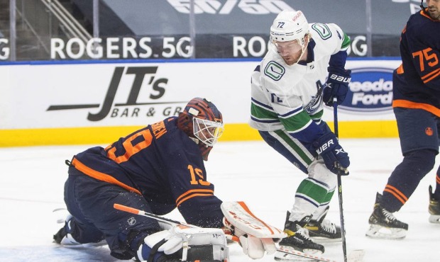Edmonton Oilers goalie Mikko Koskinen (19) makes a save against Vancouver Canucks' Travis Boyd (72)...