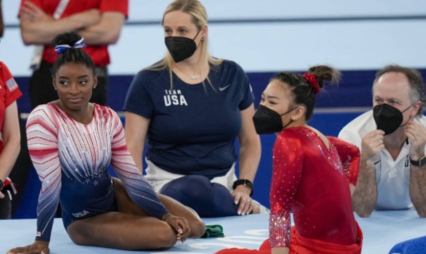 Simone Biles, of the United States, sits on the mat with teammate Sunisa Lee during the warm up pri...