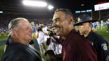 Head coach Chip Kelly of the UCLA Bruins is congratulated by head coach Herm Edwards of the Arizona...